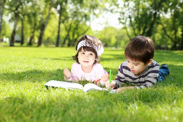 Dzieci w parku, czytanie książki — Zdjęcie stockowe