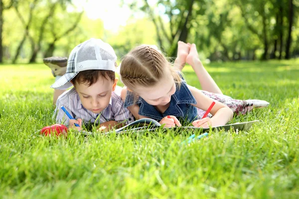 Children in the park reading a book — Stock Photo, Image