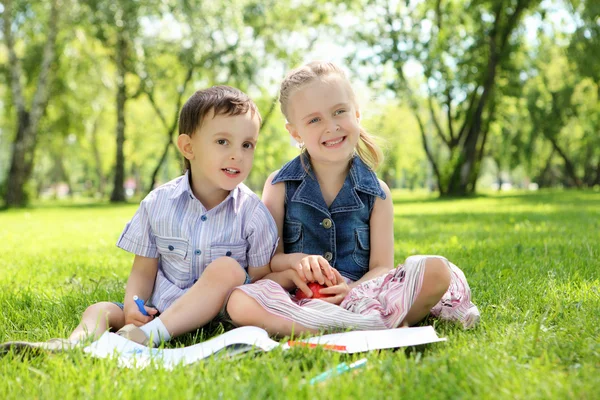 Niños en el parque leyendo un libro — Foto de Stock