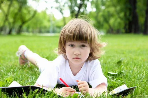 Retrato de una niña leyendo un libro en el parque —  Fotos de Stock