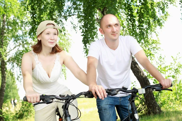 骑自行车在公园里的年轻夫妇 — 图库照片