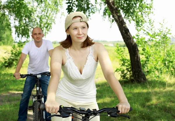 Młoda para na rowerach w parku — Zdjęcie stockowe