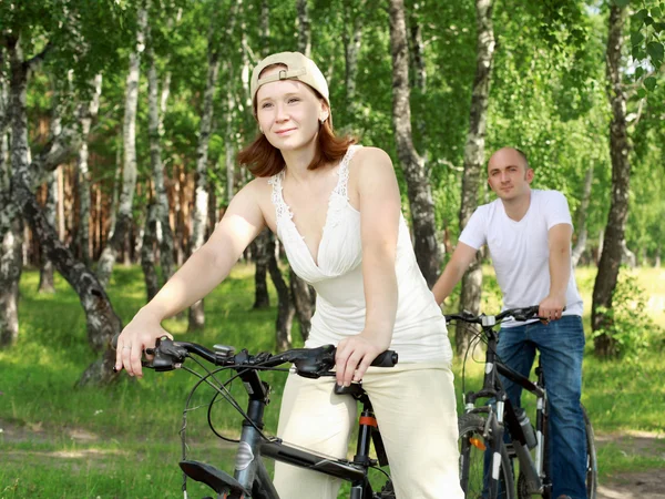 Young couple on the bikes in the park — Stock Photo, Image