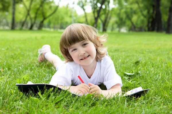 Retrato de menina lendo um livro no parque — Fotografia de Stock