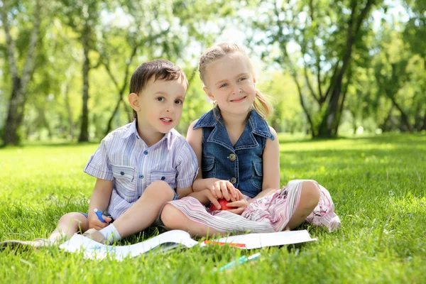 Enfants dans le parc lisant un livre — Photo