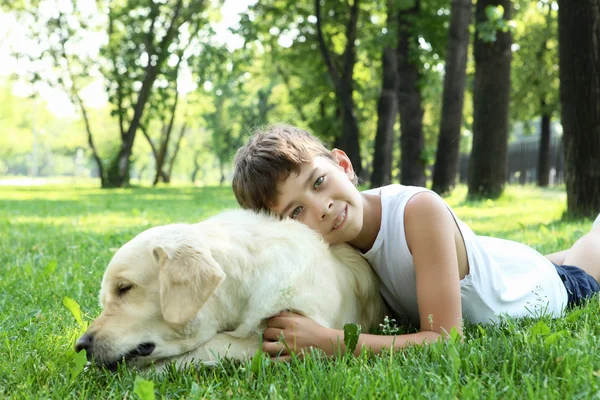 Little boy in the park with a dog — Stock Photo, Image