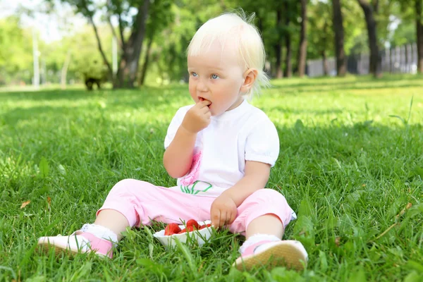Niña con fresas al aire libre — Foto de Stock