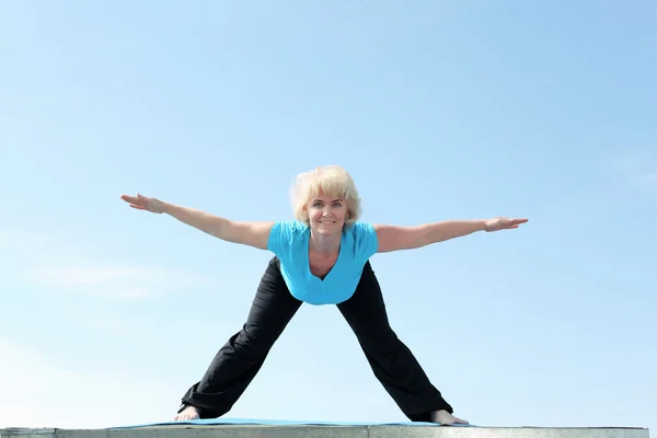 Retrato de una mujer mayor haciendo yoga — Foto de Stock