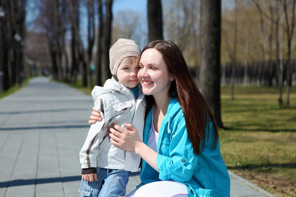 Fiatal fiú és az édesanyja sétál a parkban — Stock Fotó