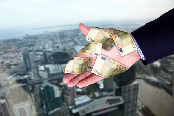 Stadtbild und Hände mit Geldscheinen — Stockfoto