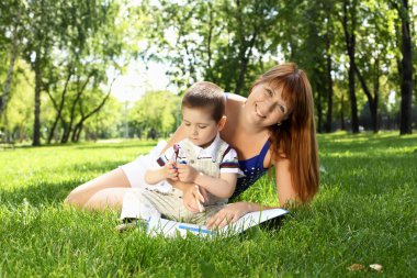 Mother with little son in the park clipart