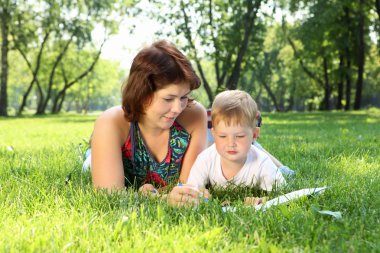 Mother with little son in the park clipart