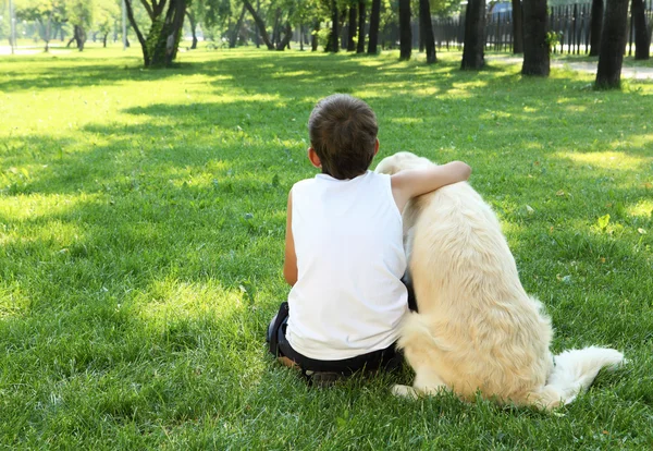 Мальчик-теннисист в парке с собакой — стоковое фото