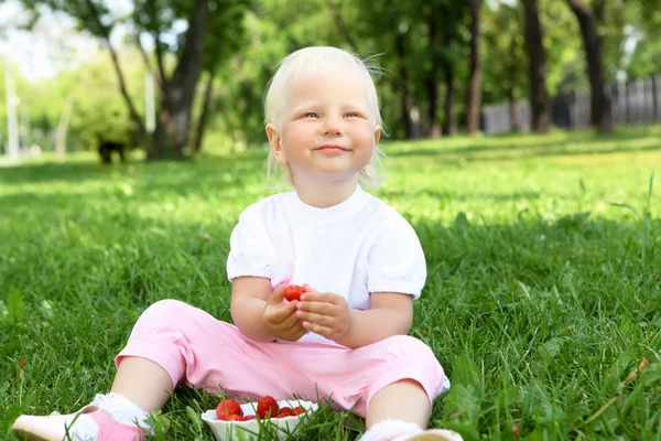 Little girl with strawberries outdoors — Stock Photo, Image