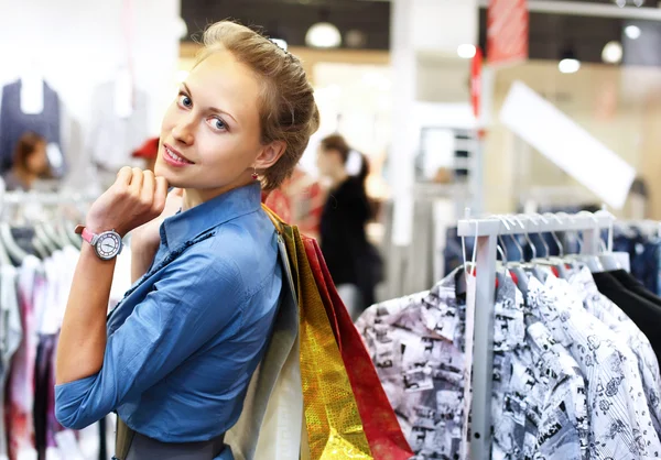 Женщина в магазине покупает одежду — стоковое фото