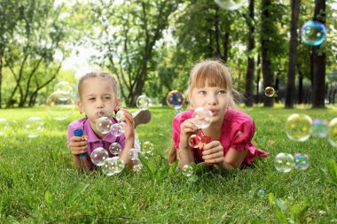 küçük kız parkta blowing bubbles