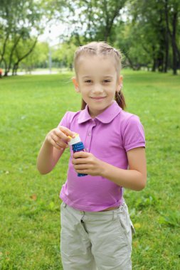 küçük kız parkta blowing bubbles