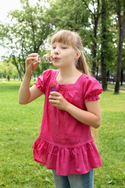 küçük kız parkta blowing bubbles