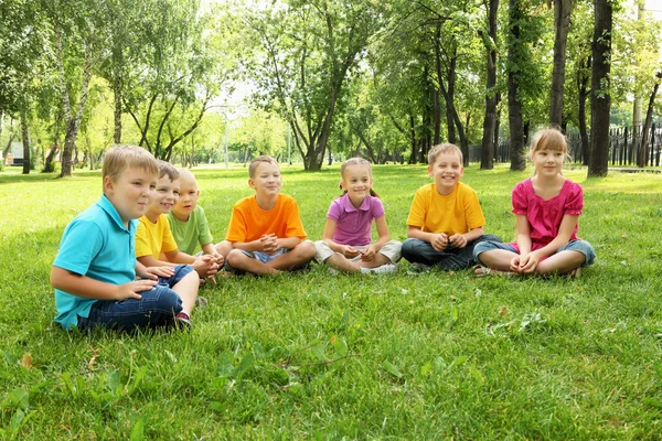 Gruppe von Kindern sitzt zusammen im Park — Stockfoto