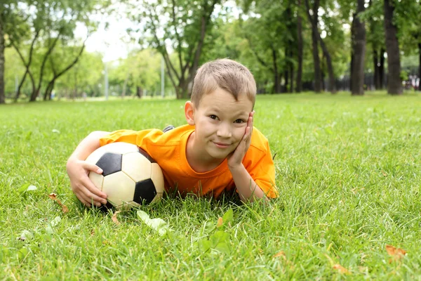 Kleine jongen in het park met een bal — Stockfoto