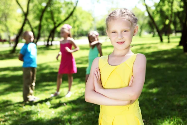Маленька дівчинка в літньому парку з друзями — стокове фото