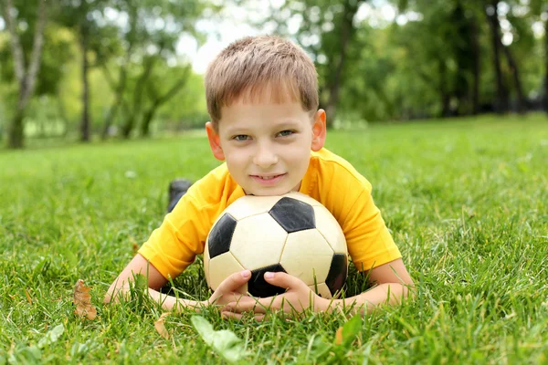 Маленький хлопчик в парку з м'ячем — стокове фото