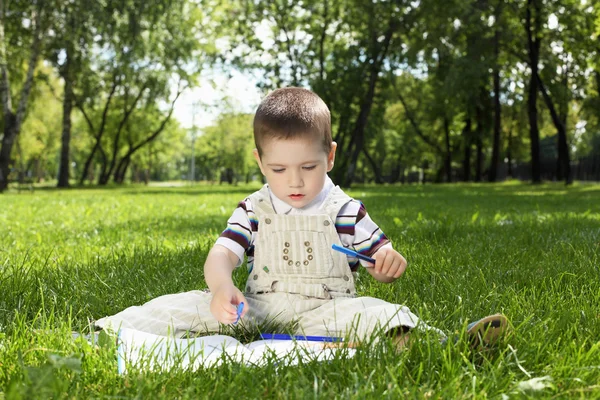 Portret chłopca z książką w parku — Zdjęcie stockowe