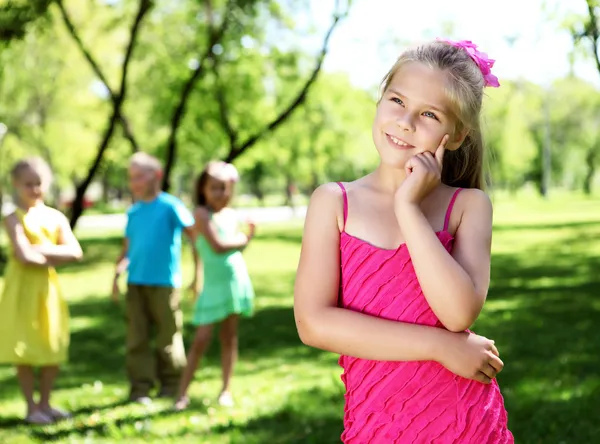 Dziewczynka w lato park z przyjaciółmi — Zdjęcie stockowe