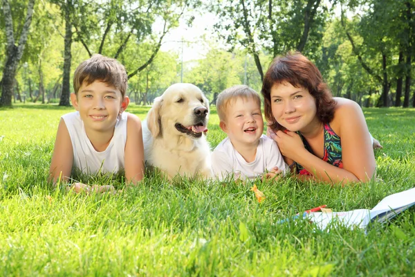 Mutter und ihre beiden Söhne mit Hund im Park — Stockfoto