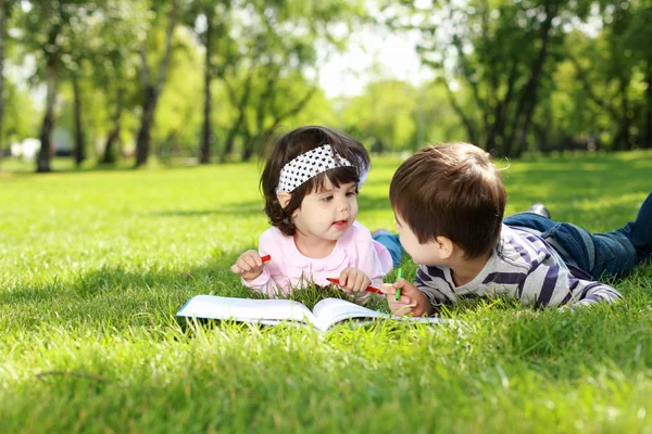Дети в парке читают книгу — стоковое фото