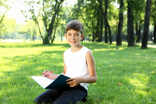 Портрет хлопчика з книгою в парку — стокове фото