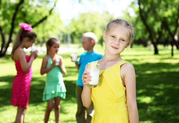 Mädchen trinkt Milch im Sommerpark — Stockfoto