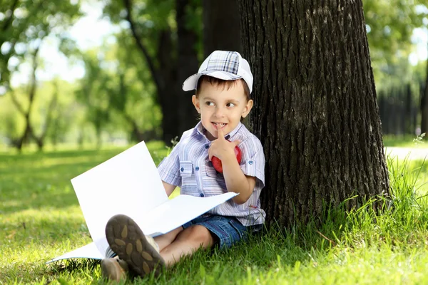 Портрет хлопчика з книгою в парку — стокове фото