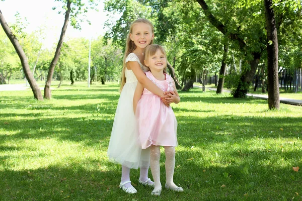 Två små systrar i parken sommaren — Stockfoto