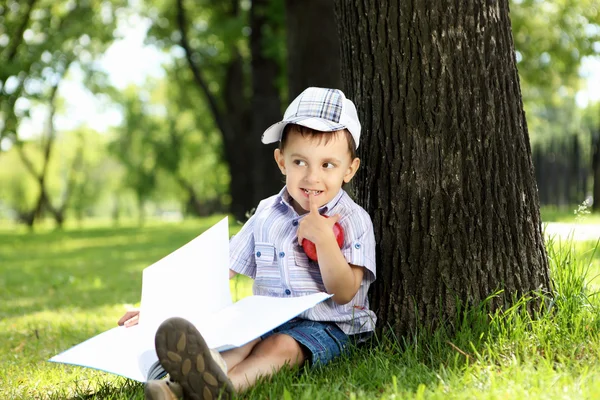 Porträtt av en pojke med en bok i parken — Stockfoto