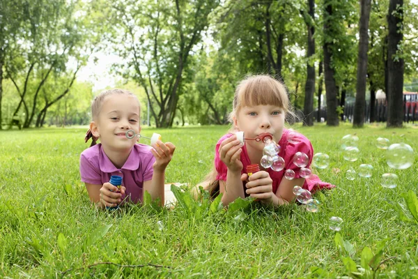 Bambina nel parco che soffia bolle — Foto Stock
