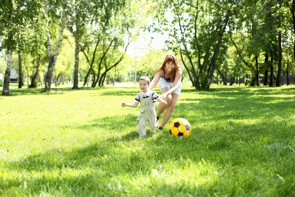 Menino no parque brincando com uma bola — Fotografia de Stock