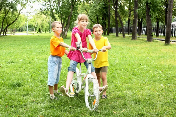 Girls with a bike in the park — Stock Photo, Image
