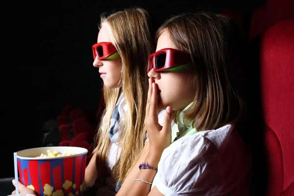 Twee jonge meisjes kijken in cinema — Stockfoto