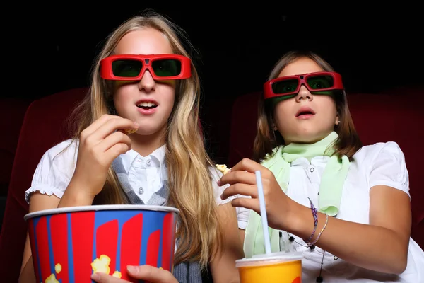 Dos chicas jóvenes mirando en el cine Imagen De Stock
