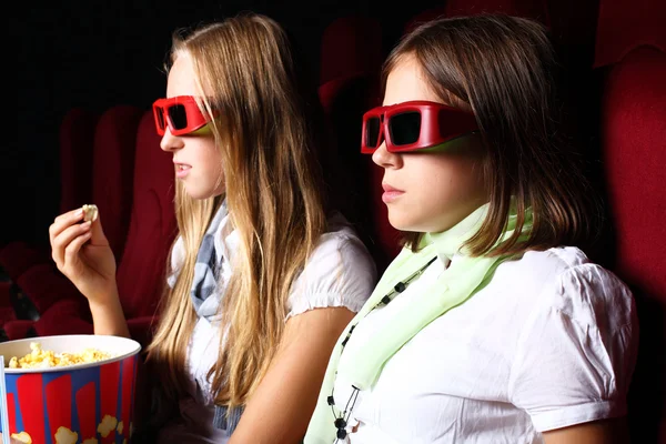Dos chicas jóvenes mirando en el cine Imagen De Stock