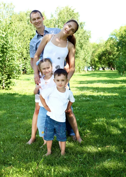 Οικογένεια με δύο παιδιά στο πάρκο καλοκαίρι — Φωτογραφία Αρχείου