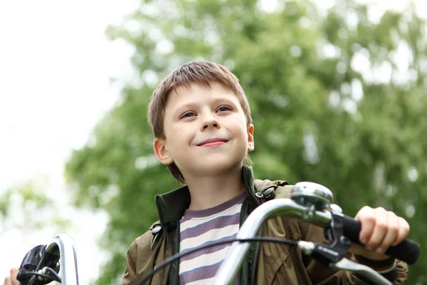Chlapec na kole v zeleném parku — Stock fotografie