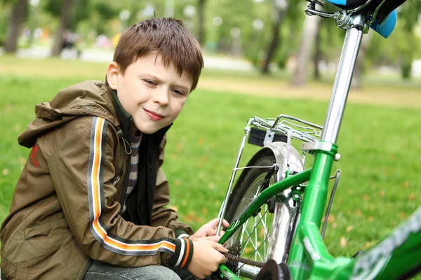 男孩骑着自行车在绿色公园 — 图库照片