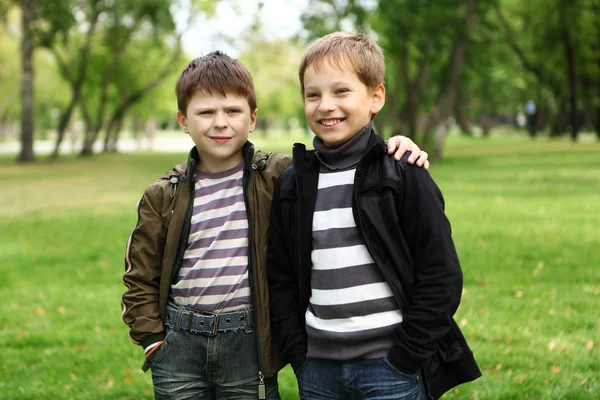 Niño con un amigo en el parque verde —  Fotos de Stock