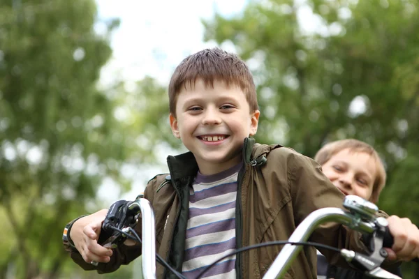 Garçon sur un vélo dans le parc vert — Photo