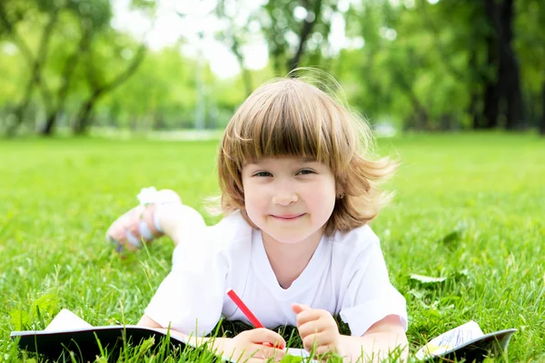 Portrait of little girl reading a book in the park Stock Image