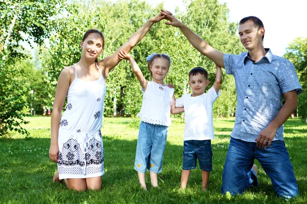 Rodzina z dwójką dzieci w parku lato — Zdjęcie stockowe