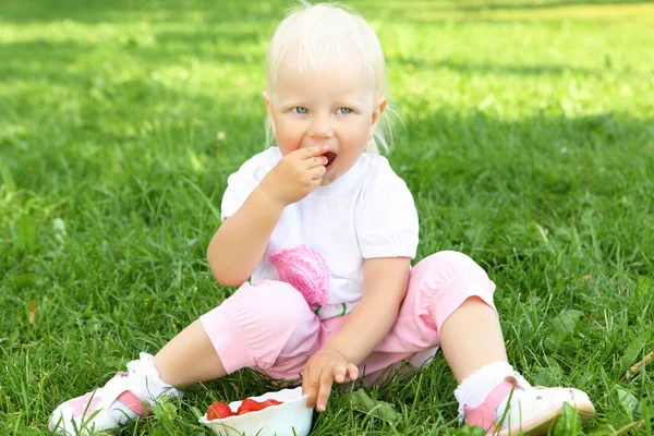Liten flicka med jordgubbar utomhus — Stockfoto