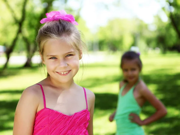 Little girl in summer park with friends — Stock Photo, Image